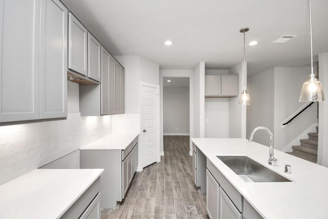 11106 Crocus Dr, Houston, TX 77044 - kitchen featuring gray cabinetry, backsplash, light wood-style floors, recessed lighting, and light countertops