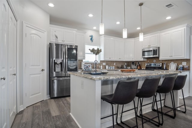 956 Biscayne, Crystal Beach, TX 77650 - kitchen with appliances with stainless steel finishes, a center island, dark wood-style floors, white cabinets, and backsplash