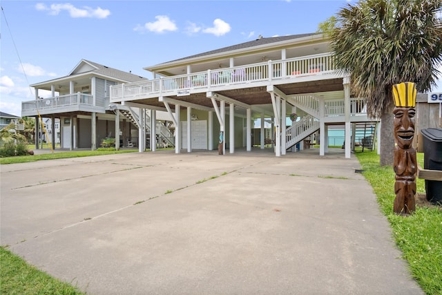 956 Biscayne, Crystal Beach, TX 77650 - coastal home with stairs, a carport, driveway, a porch, and an attached garage