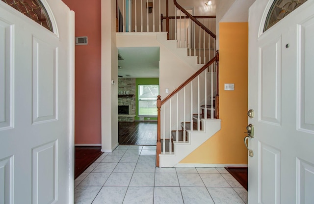 15731 Oak Mountain Dr, Houston, TX 77095 - entrance foyer featuring stairs, a stone fireplace, tile patterned floors, and a towering ceiling