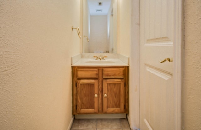 15731 Oak Mountain Dr, Houston, TX 77095 - bathroom featuring a textured wall, vanity, and tile patterned floors