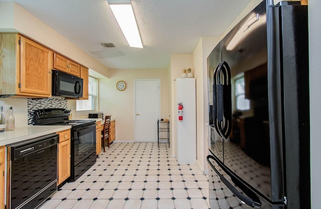15731 Oak Mountain Dr, Houston, TX 77095 - kitchen with black appliances, light floors, light countertops, and tasteful backsplash