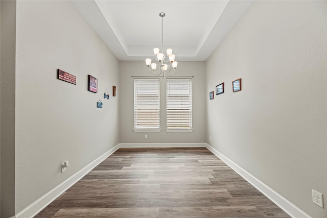 2922 Muhley St, Katy, TX 77493 - unfurnished dining area with a chandelier, a raised ceiling, and wood finished floors
