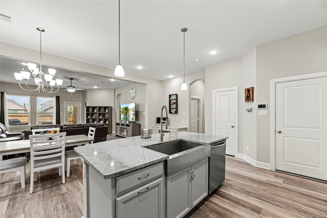 2922 Muhley St, Katy, TX 77493 - kitchen with stainless steel dishwasher, light wood finished floors, gray cabinets, open floor plan, and recessed lighting