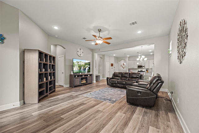 2922 Muhley St, Katy, TX 77493 - living area featuring light wood-style flooring, ceiling fan, arched walkways, recessed lighting, and a chandelier