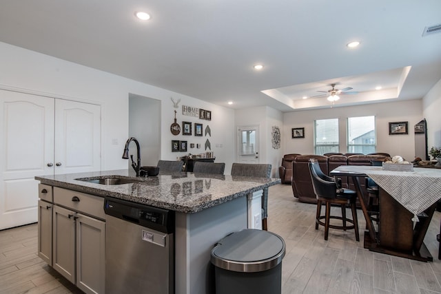 8023 Royal Palm Dr, Fulshear, TX 77441 - kitchen with stainless steel dishwasher, light wood-style floors, a ceiling fan, open floor plan, and dark stone countertops