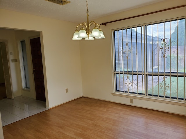 9206 Beringwood Dr, Houston, TX 77083 - spare room featuring wood finished floors, plenty of natural light, and a chandelier