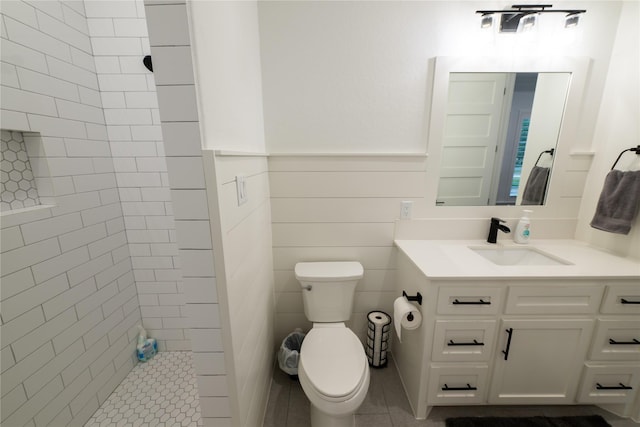 14646 Whistling Oak Dr, Conroe, TX 77356 - full bath featuring vanity, tiled shower, wainscoting, and tile patterned flooring