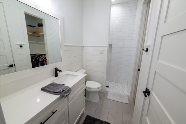 14646 Whistling Oak Dr, Conroe, TX 77356 - full bathroom with vanity, walk in shower, tile patterned flooring, a spacious closet, and a wainscoted wall