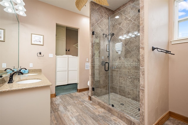 973 Kenlyn Dr, Crystal Beach, TX 77650 - full bathroom featuring wood finished floors, a stall shower, and double vanity