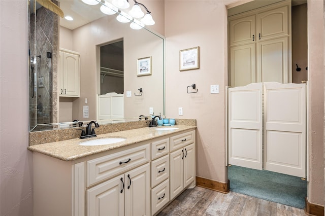 973 Kenlyn Dr, Crystal Beach, TX 77650 - bathroom featuring a closet, wood finished floors, and double vanity