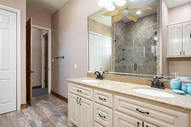 973 Kenlyn Dr, Crystal Beach, TX 77650 - bathroom featuring double vanity, a shower stall, wood finished floors, and a ceiling fan