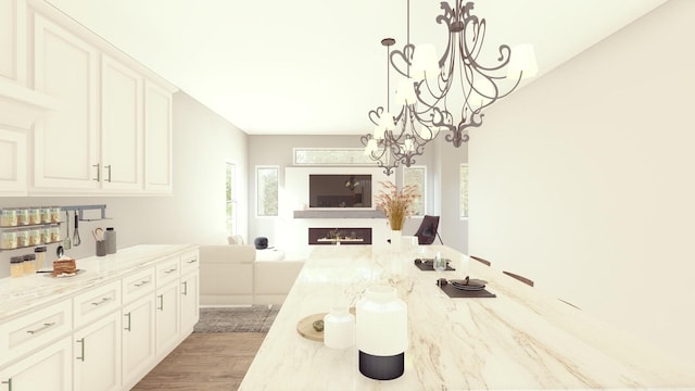 1804 65th St Unit A, Galveston, TX 77551 - kitchen with a chandelier, open floor plan, light stone counters, and white cabinetry
