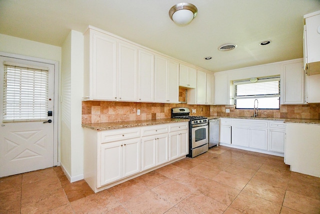4114 Lemac Dr, Houston, TX 77025 - kitchen featuring stainless steel gas range, dishwashing machine, decorative backsplash, light stone counters, and white cabinetry