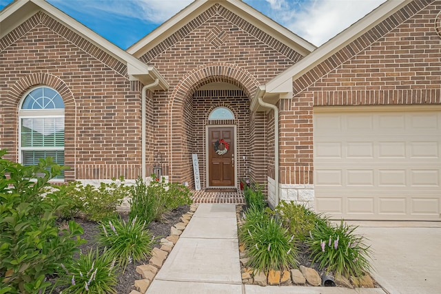 406 Riesling Dr, Alvin, TX 77511 - view of exterior entry with brick siding, an attached garage, and driveway