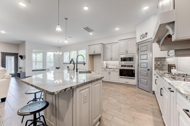 28723 Eden Creek Trl, Fulshear, TX 77441 - kitchen with appliances with stainless steel finishes, a breakfast bar, tasteful backsplash, open floor plan, and recessed lighting