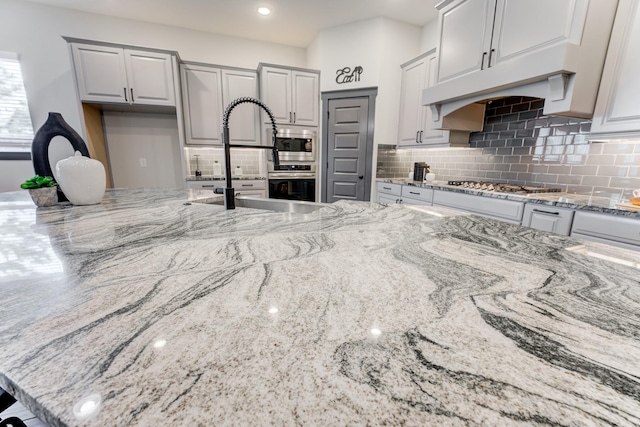 28723 Eden Creek Trl, Fulshear, TX 77441 - kitchen featuring stainless steel appliances, light stone countertops, and decorative backsplash