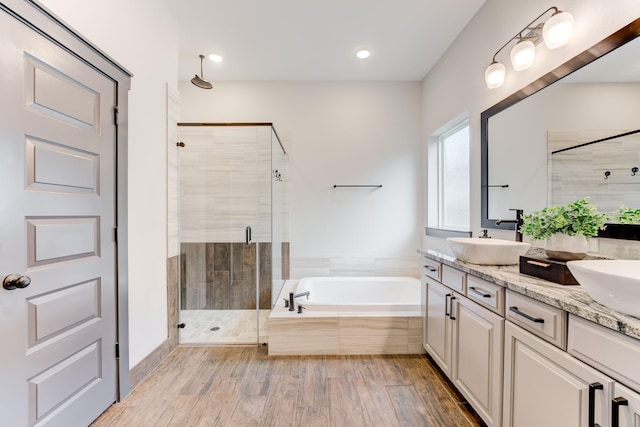 28723 Eden Creek Trl, Fulshear, TX 77441 - bathroom featuring a stall shower, double vanity, a bath, wood finished floors, and recessed lighting