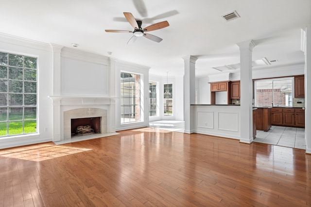 4919 Glen Hollow St, Sugar Land, TX 77479 - unfurnished living room with a ceiling fan, light wood-type flooring, a high end fireplace, decorative columns, and ornamental molding