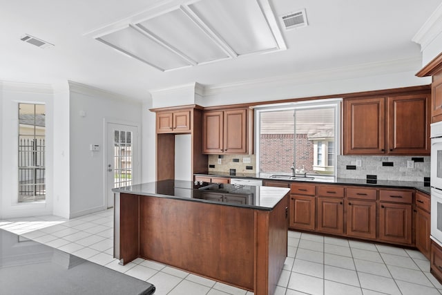 4919 Glen Hollow St, Sugar Land, TX 77479 - kitchen featuring dark countertops, crown molding, light tile patterned flooring, decorative backsplash, and a kitchen island