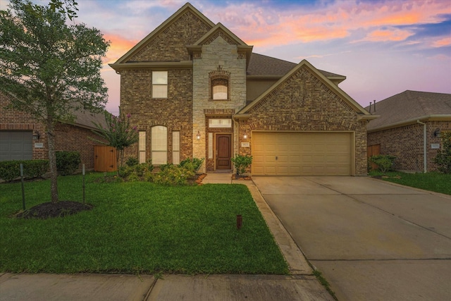 3823 Fleetwood Falls Ln, Spring, TX 77386 - view of front of home with driveway, an attached garage, a lawn, stone siding, and brick siding