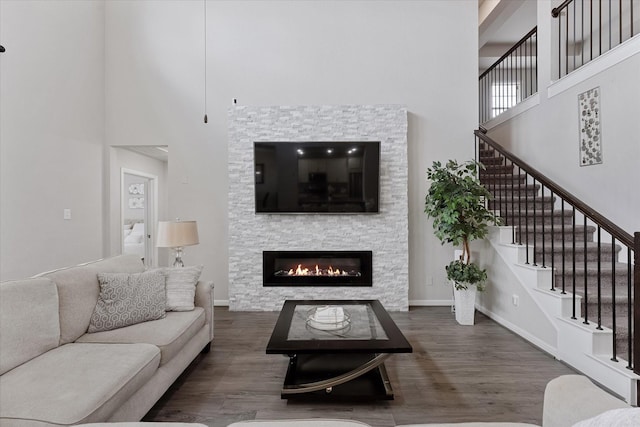 3823 Fleetwood Falls Ln, Spring, TX 77386 - living room featuring a high ceiling, stairway, wood finished floors, and a stone fireplace