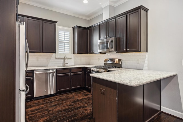 1707 Crockett St Unit A, Houston, TX 77007 - kitchen featuring stainless steel appliances, a peninsula, dark wood finished floors, dark brown cabinetry, and ornamental molding