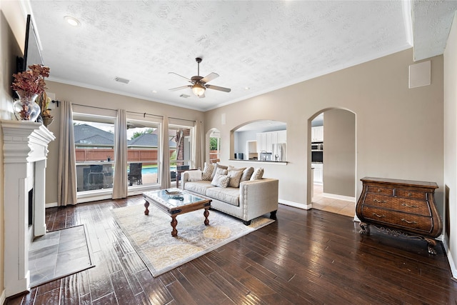 12543 Country Arbor Ln, Houston, TX 77041 - living area with a ceiling fan, a textured ceiling, a fireplace with flush hearth, wood-type flooring, and arched walkways