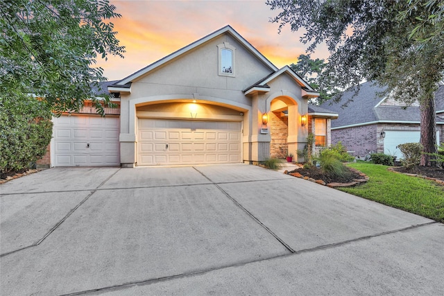 66 N Rocky Point Cir, Spring, TX 77389 - view of front of home with concrete driveway, stucco siding, and an attached garage