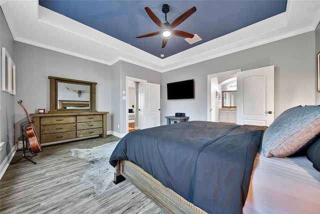 66 N Rocky Point Cir, Spring, TX 77389 - bedroom featuring a raised ceiling, wood finished floors, ensuite bathroom, crown molding, and ceiling fan