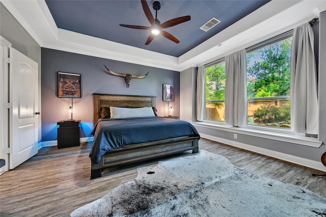 66 N Rocky Point Cir, Spring, TX 77389 - bedroom with a tray ceiling, wood finished floors, and a ceiling fan
