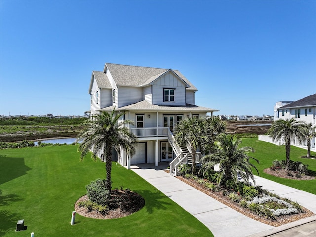 3914 Curlew Dr, Galveston, TX 77554 - raised beach house featuring stairs, a water view, a front lawn, board and batten siding, and covered porch