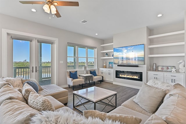 3914 Curlew Dr, Galveston, TX 77554 - living area with a glass covered fireplace, ceiling fan, recessed lighting, dark wood-type flooring, and built in features