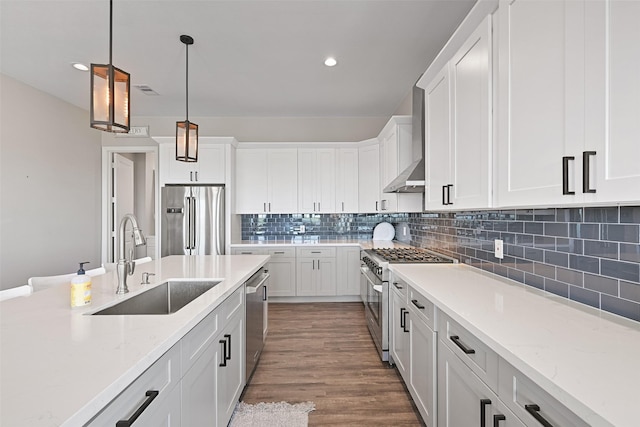 3914 Curlew Dr, Galveston, TX 77554 - kitchen featuring stainless steel appliances, white cabinetry, decorative light fixtures, backsplash, and light stone countertops