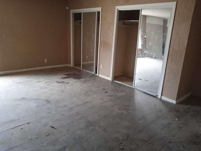 1807 E 1st St, Lubbock, TX 79403 - unfurnished bedroom featuring multiple closets and baseboards