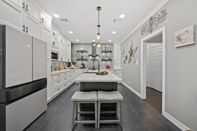 2516 Bagby St, Houston, TX 77006 - kitchen with freestanding refrigerator, wall chimney exhaust hood, stainless steel microwave, backsplash, and white cabinetry