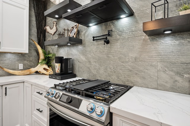 2516 Bagby St, Houston, TX 77006 - kitchen featuring stainless steel range with gas cooktop, extractor fan, tasteful backsplash, open shelves, and white cabinetry