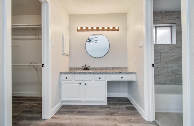 2207 S Ferrisburg Ct, Sugar Land, TX 77478 - bathroom with vanity, a walk in closet, and wood finished floors