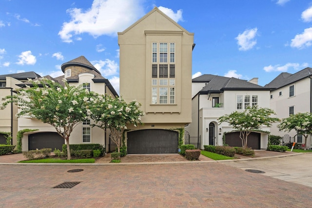 1753 Upland Lks, Houston, TX 77043 - view of front of home featuring stucco siding, decorative driveway, and an attached garage