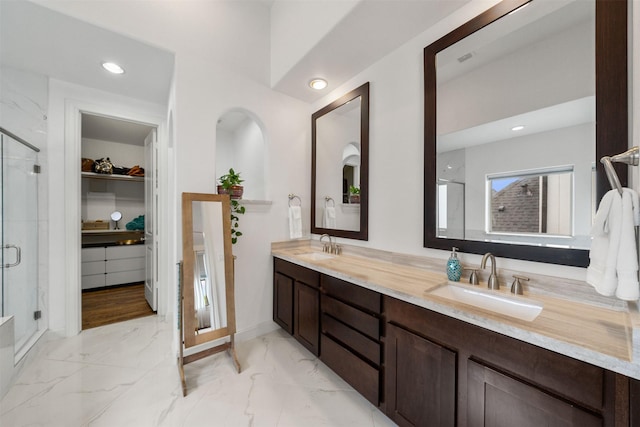 1753 Upland Lks, Houston, TX 77043 - full bath featuring double vanity, a shower stall, marble finish flooring, a walk in closet, and recessed lighting