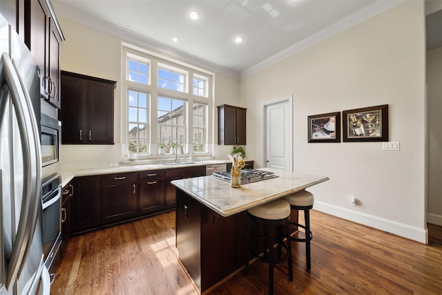 1753 Upland Lks, Houston, TX 77043 - kitchen with crown molding, appliances with stainless steel finishes, dark brown cabinets, a center island, and dark wood-style flooring