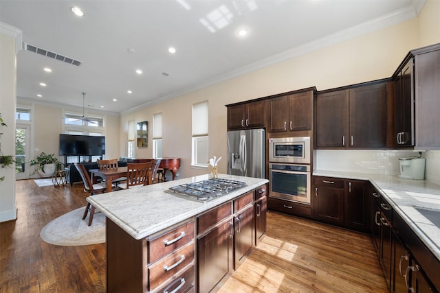 1753 Upland Lks, Houston, TX 77043 - kitchen with stainless steel appliances, open floor plan, crown molding, light wood-type flooring, and recessed lighting