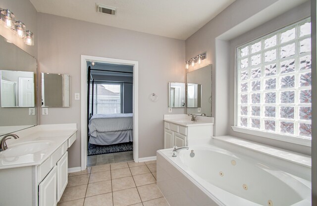 12807 Sienna Trails Dr, Tomball, TX 77377 - ensuite bathroom featuring plenty of natural light, a jetted tub, two vanities, and tile patterned flooring