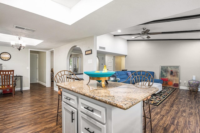 5427 Cairnleigh Dr, Houston, TX 77084 - kitchen with a breakfast bar area, dark wood finished floors, white cabinets, arched walkways, and a ceiling fan