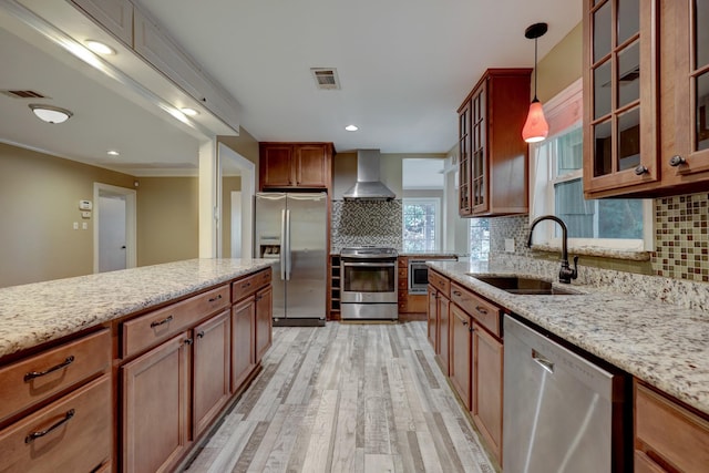 5502 Lincrest Ln, Houston, TX 77056 - kitchen featuring stainless steel appliances, wall chimney range hood, light wood-type flooring, decorative backsplash, and recessed lighting