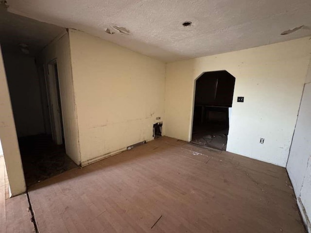 506 E Ursuline St, Lubbock, TX 79403 - empty room with arched walkways, a textured ceiling, and light wood-style floors