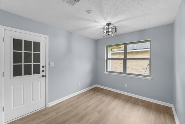 14234 Cellini Dr, Cypress, TX 77429 - unfurnished room featuring a chandelier, a textured ceiling, and light wood-style flooring