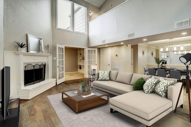 11012 Francoise Blvd, Houston, TX 77042 - living room with a towering ceiling, wood finished floors, a chandelier, a fireplace, and french doors