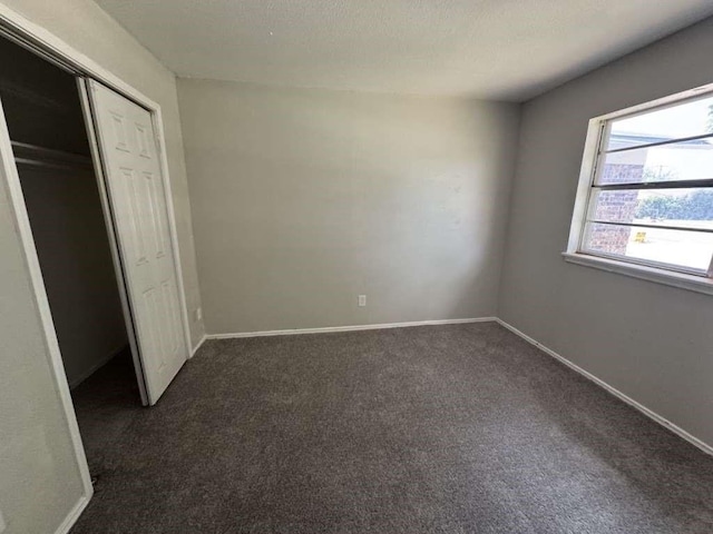 5431 45th St, Lubbock, TX 79414 - unfurnished bedroom featuring dark carpet and a closet