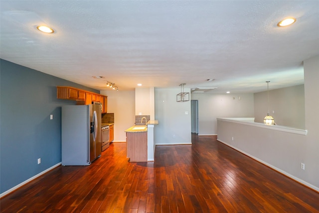 1515 Saulnier St, Houston, TX 77019 - kitchen featuring appliances with stainless steel finishes, brown cabinets, dark wood-type flooring, open floor plan, and recessed lighting